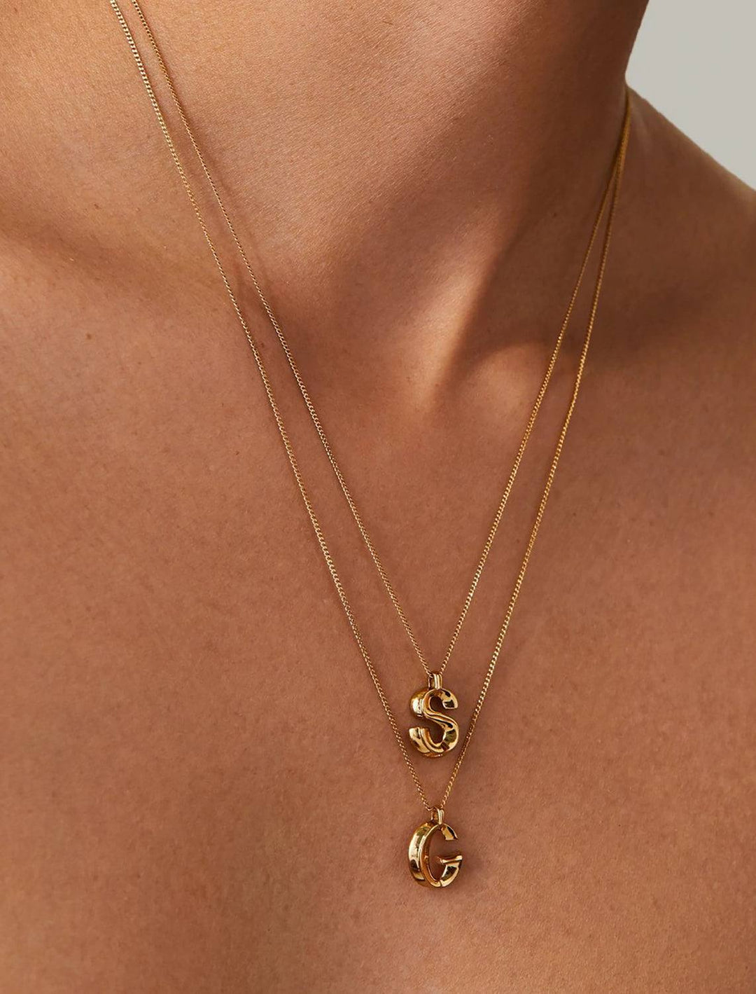 model wearing monogram necklace in gold | S