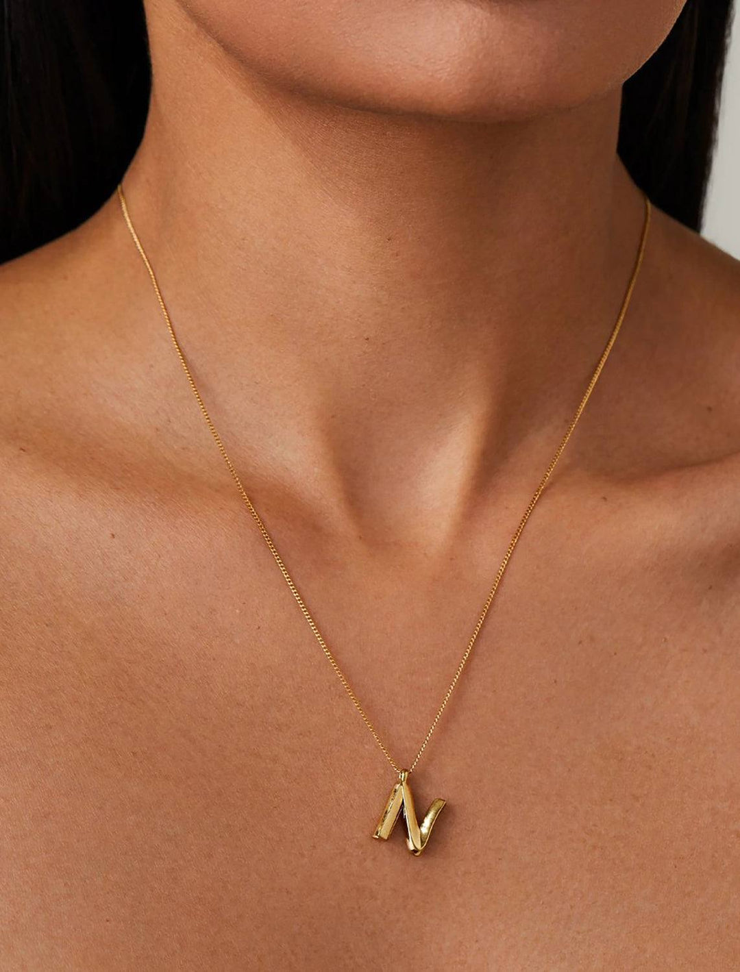 model wearing monogram necklace in gold | N