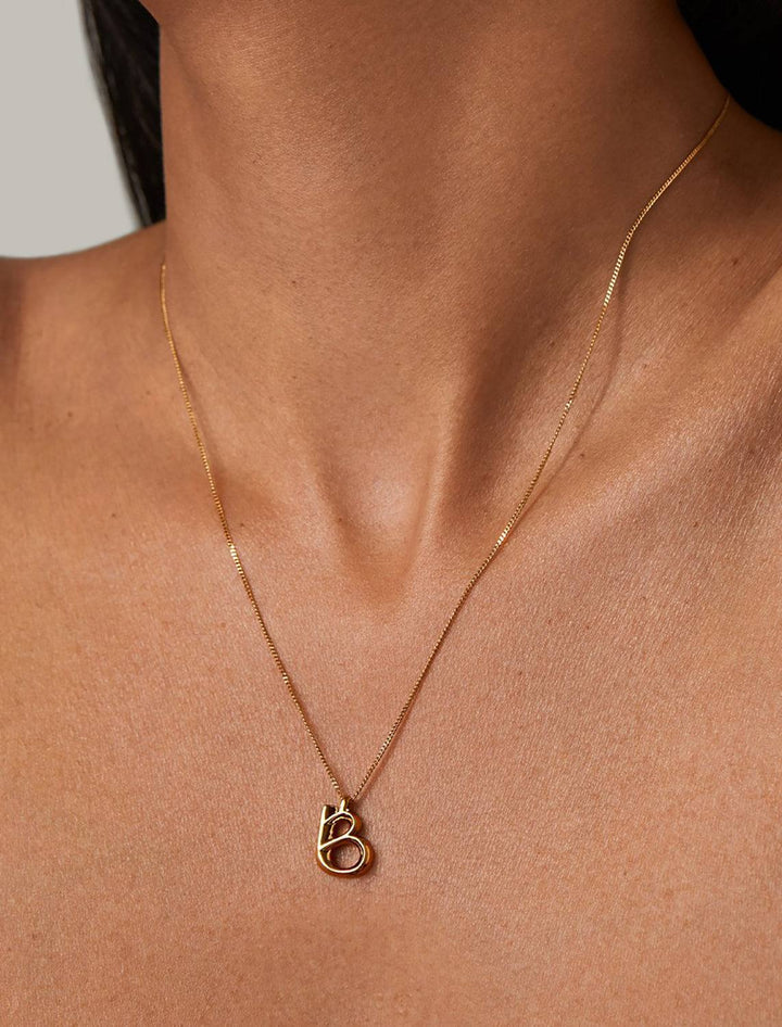 model wearing monogram necklace in gold | B