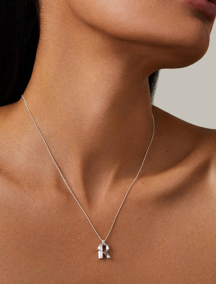 model wearing monogram necklace in silver | R