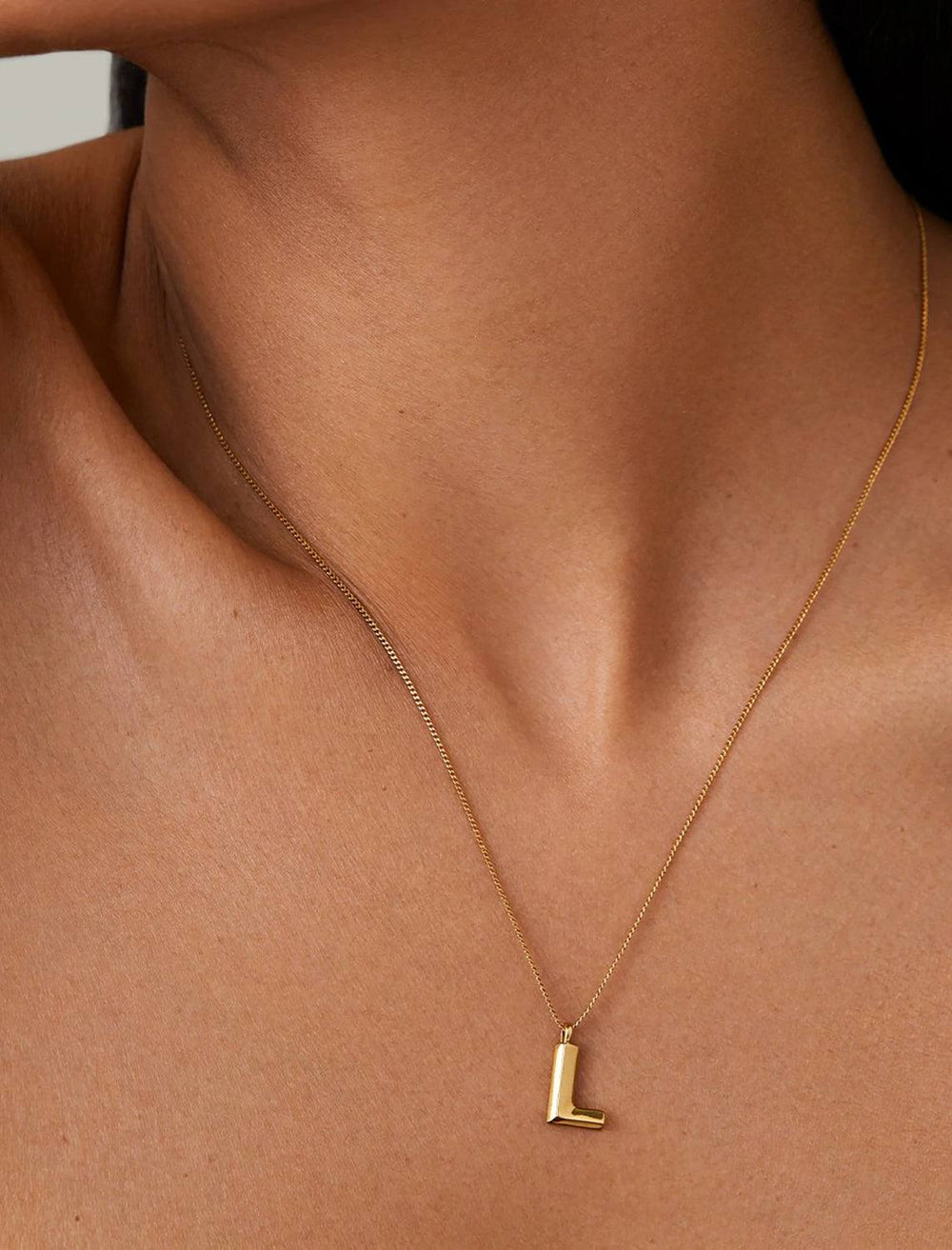 model wearing monogram necklace in gold | L