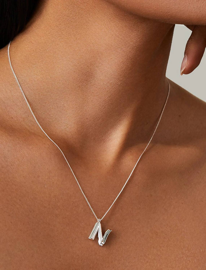 model wearing monogram necklace in silver| N