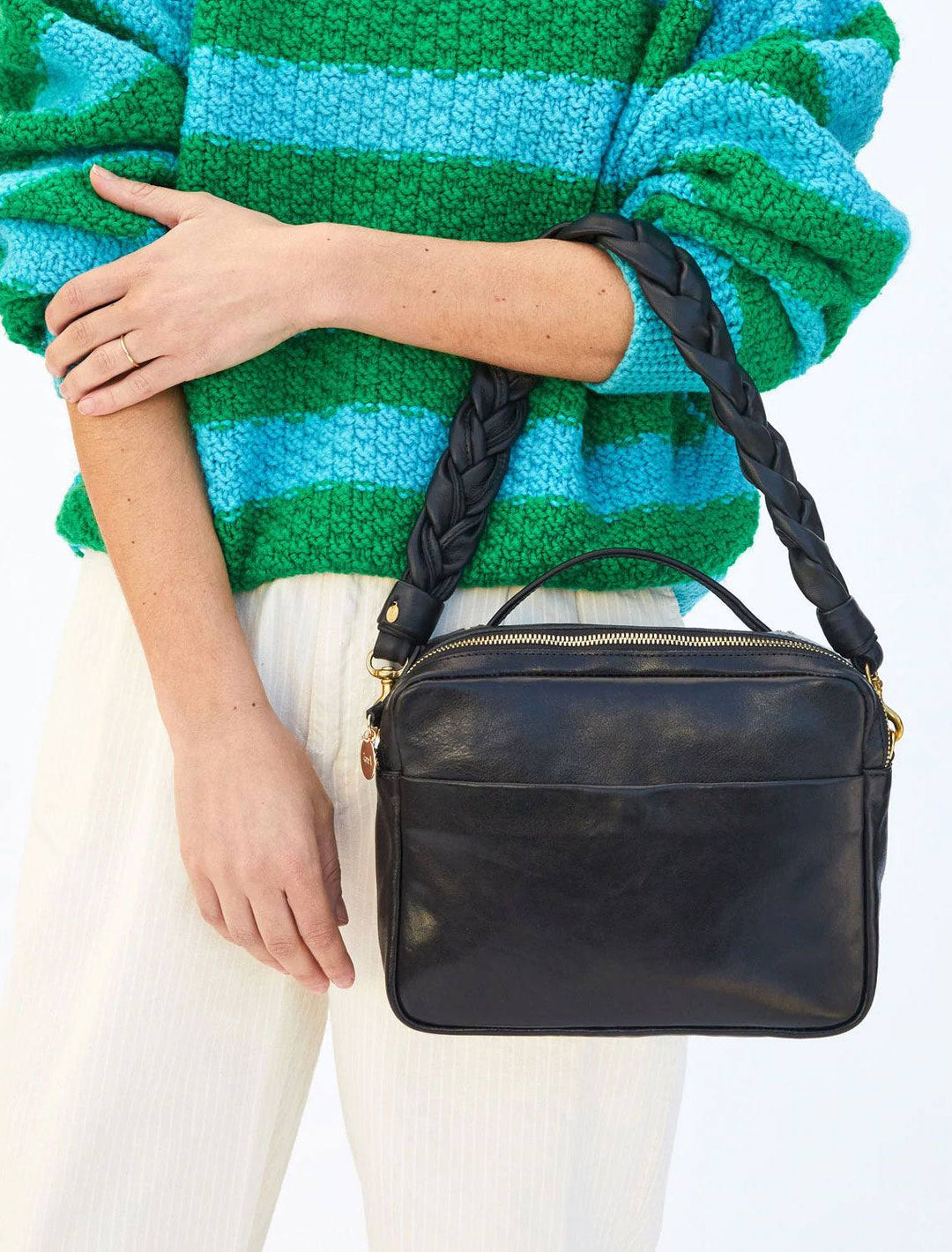 model carrying midi sac with the braided leather shoulder strap in black attached on d-rings