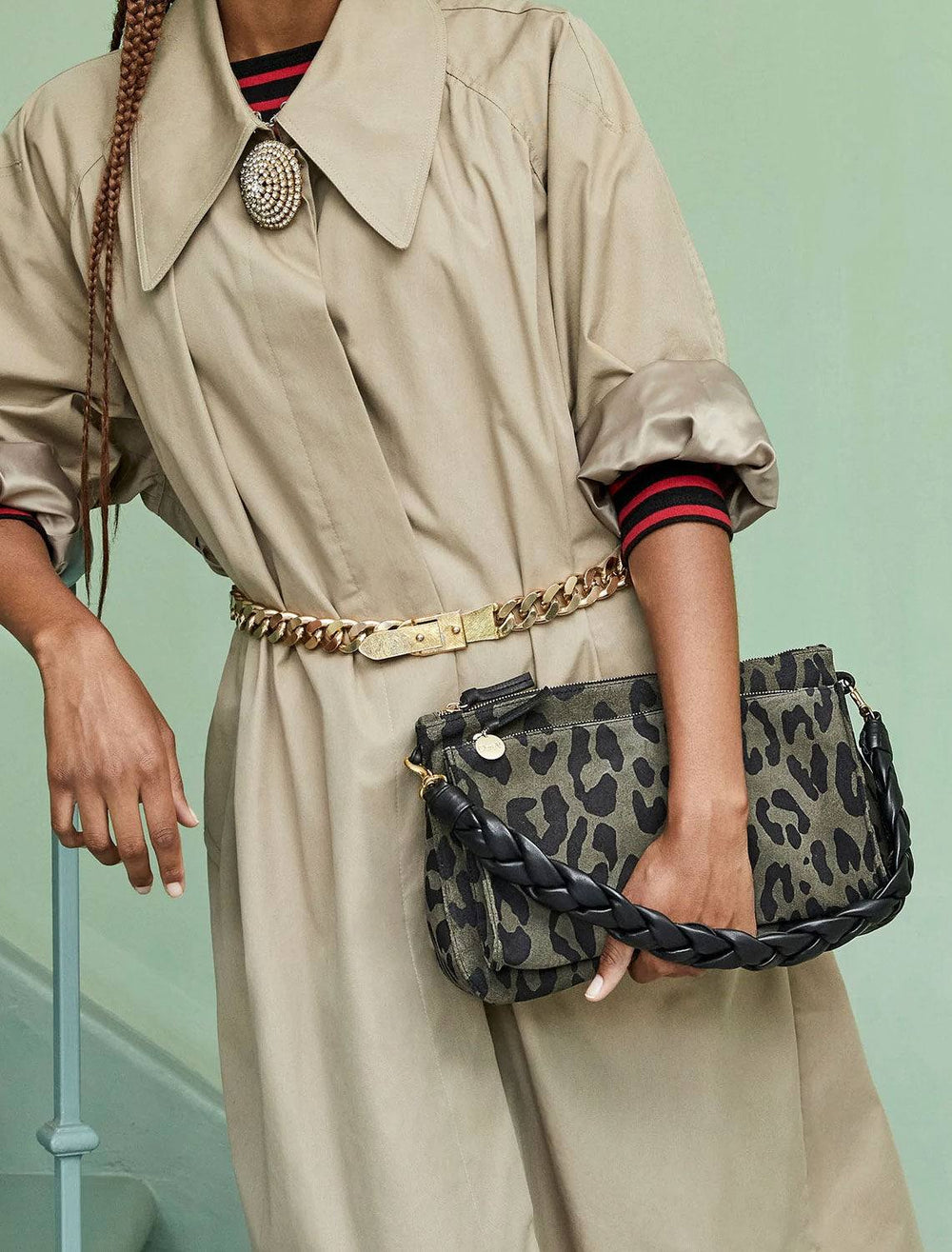model carrying braided leather shoulder strap in black on olive leopard handbag. handbag not included