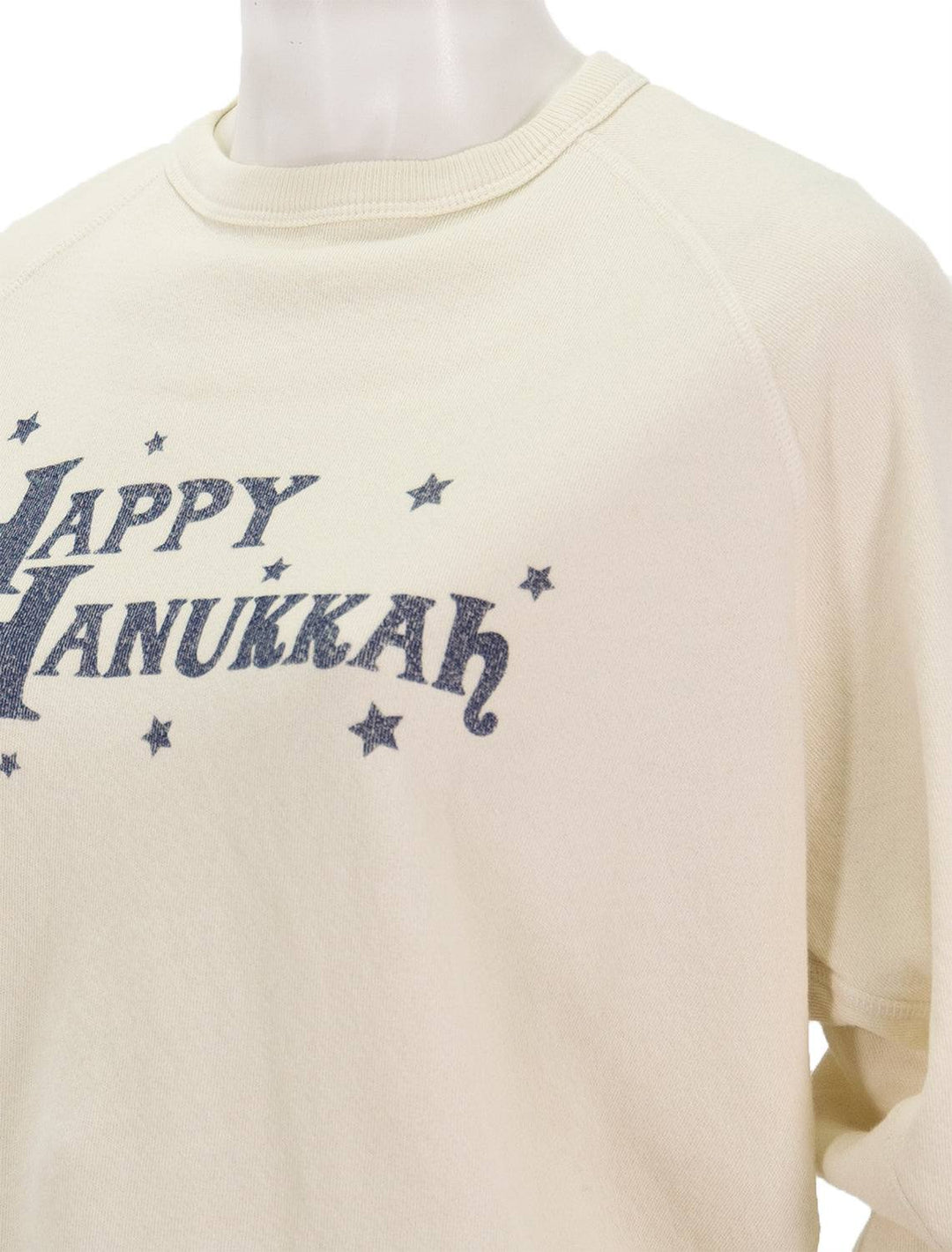 Close-up view of The Great's happy hanukkah college sweatshirt in washed white.