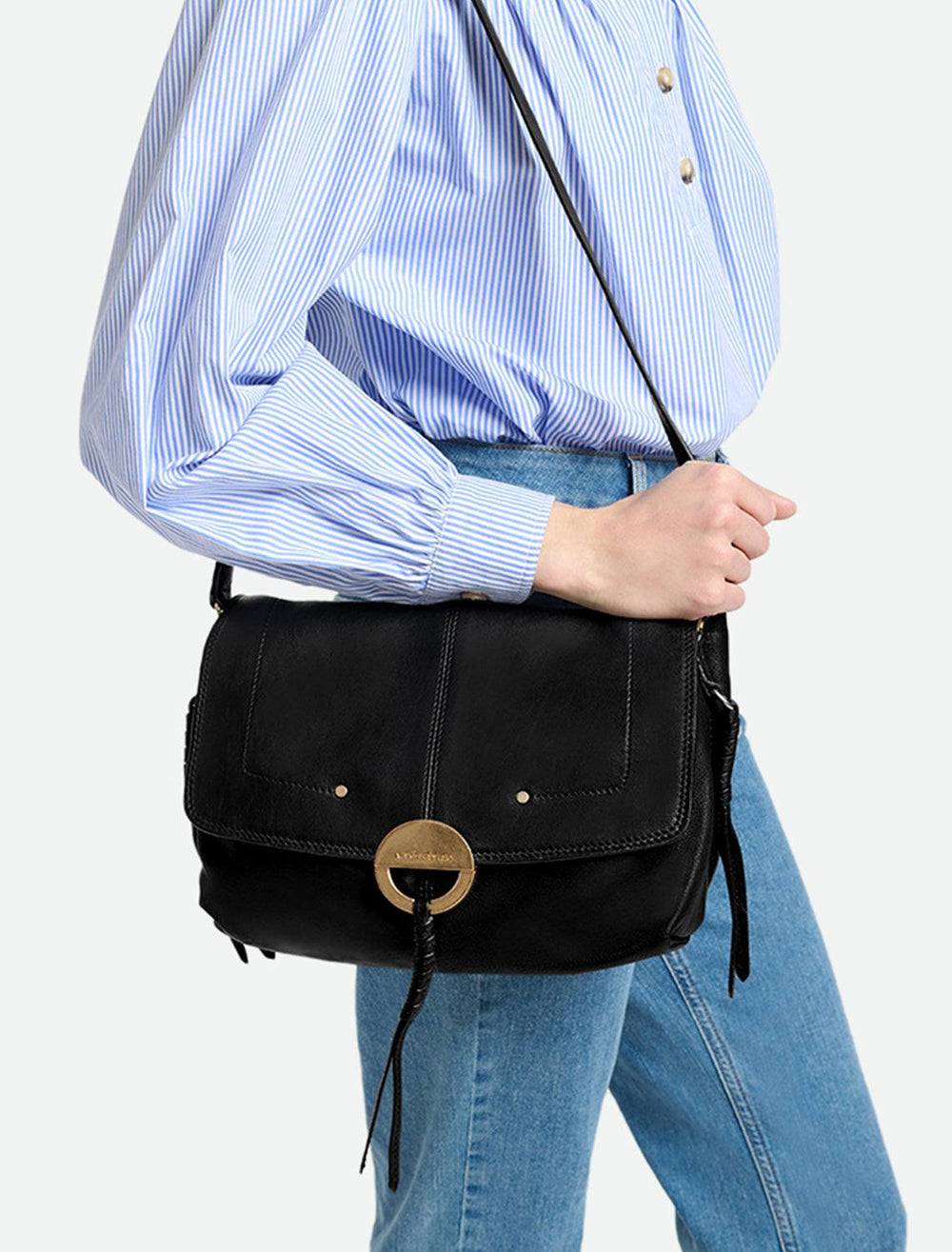 Model holding Vanessa Bruno's crossbody gm handbag in noir.