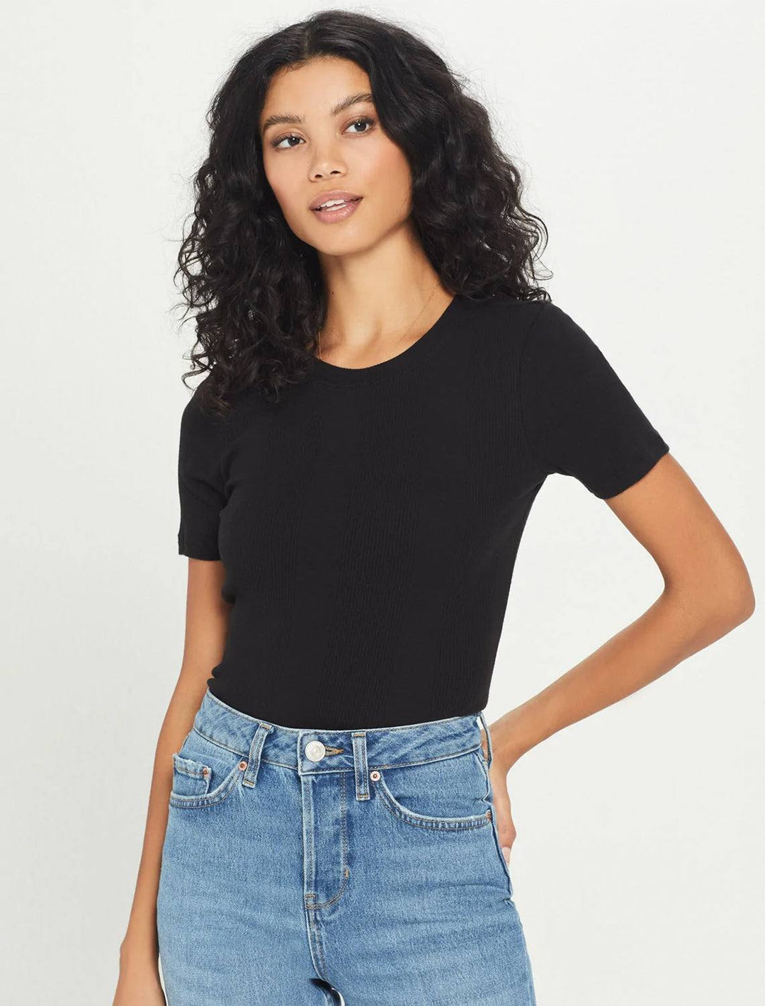 model wearing cotton rib tee in black with mid-wash jeans
