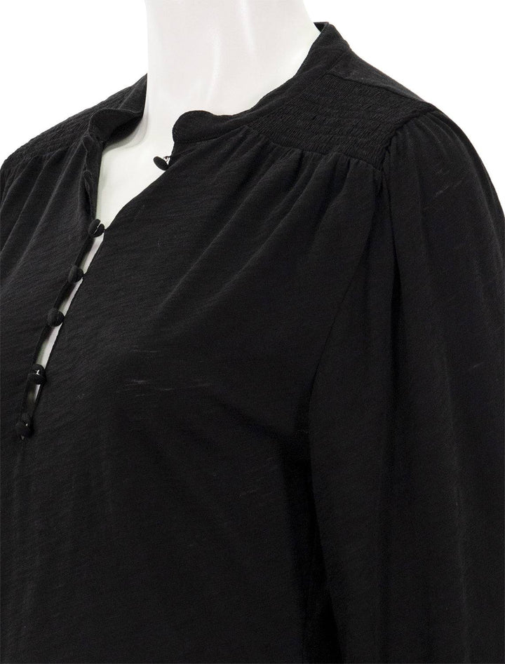 Close-up view of Goldie Lewinter's peasant blouse with smocking in black.