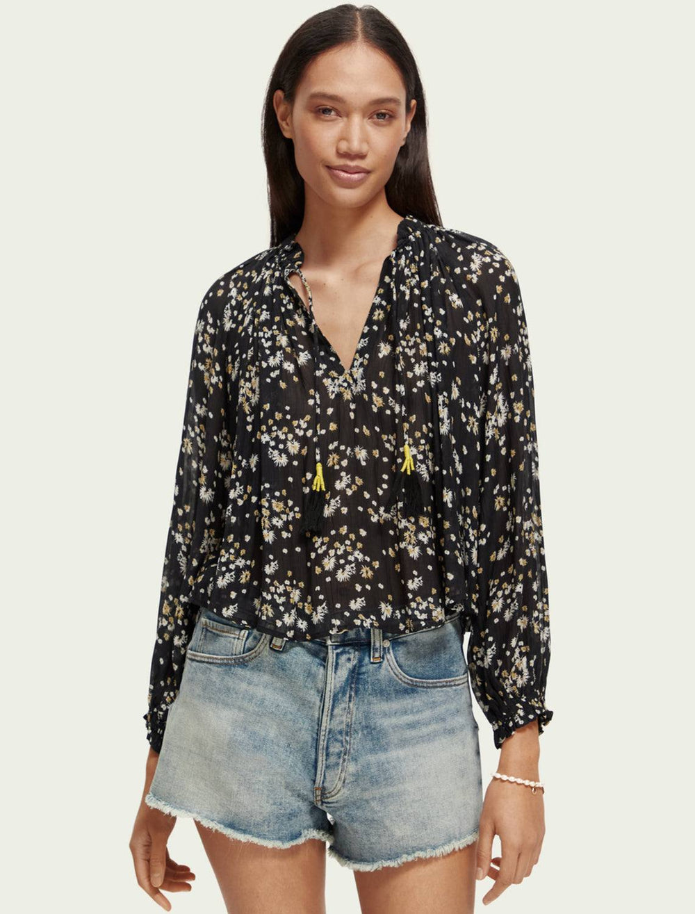 Model wearing Scotch & Soda's dandelion print contrast ruffle blouse in black.