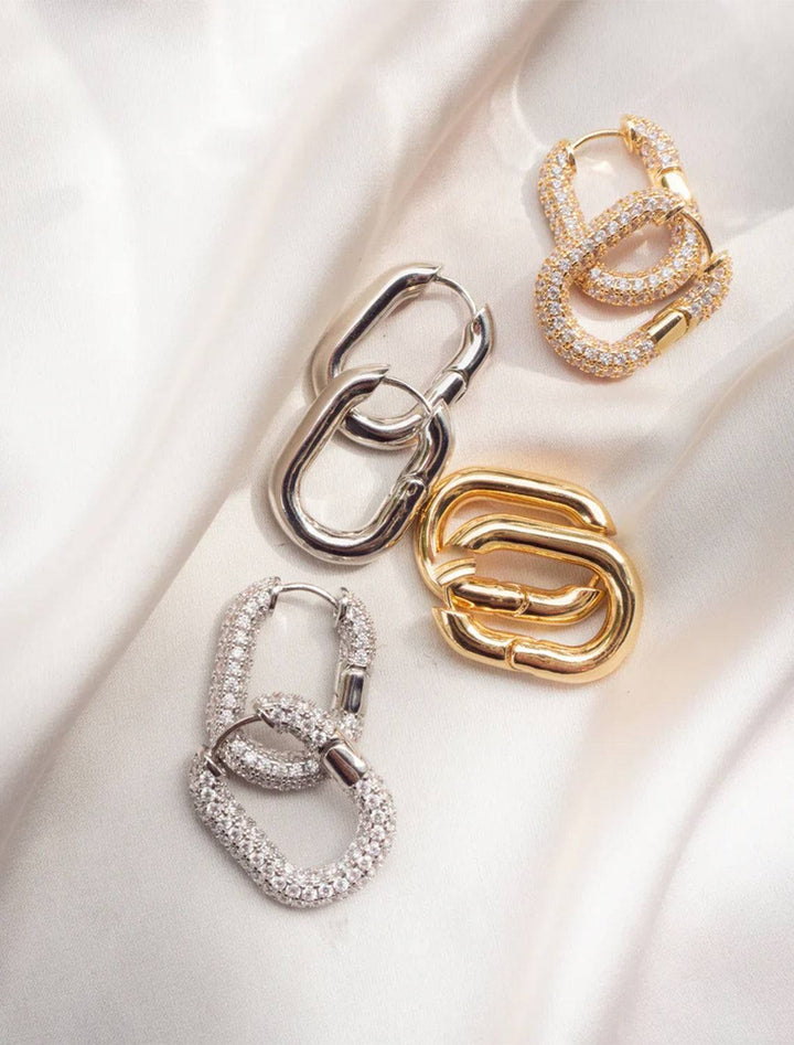 Stylized laydown of Luv AJ's xl chain link hoops in gold.