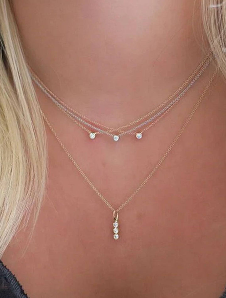 Model wearing Zoe Chicco's 14k three stone diamond bar necklace.