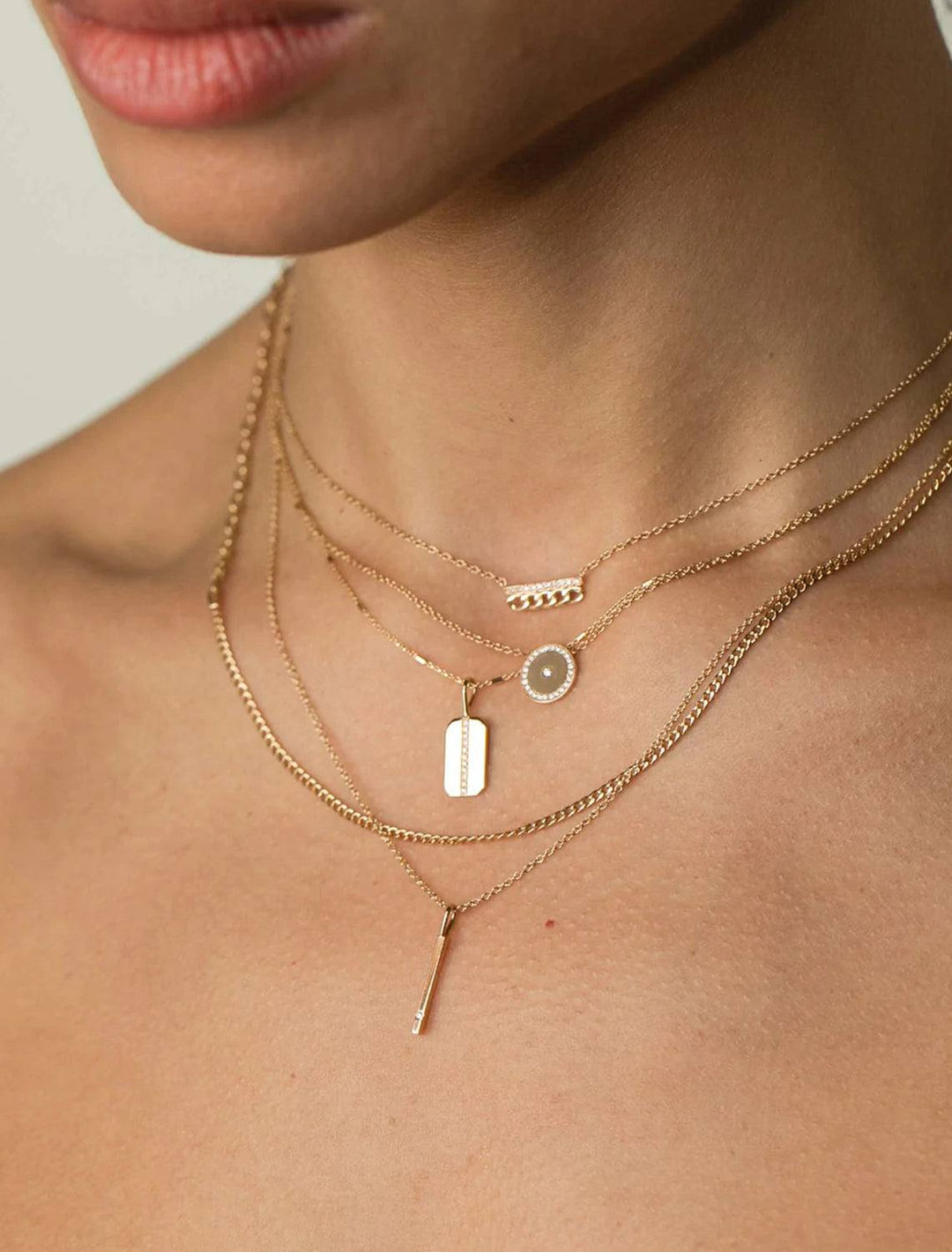 Model wearing Zoe Chicco's 14K single diamond vertical bar pendant necklace.