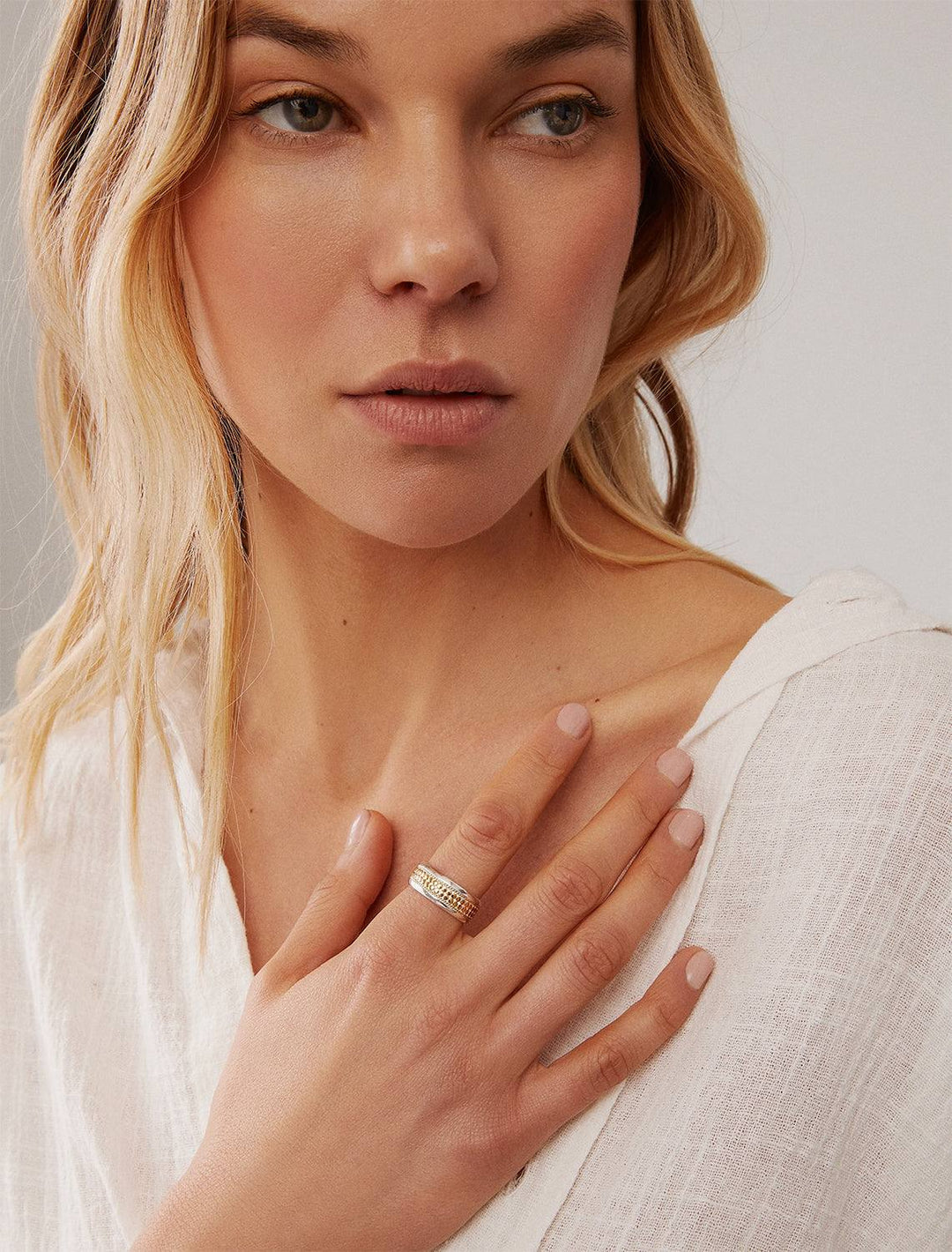 Model wearing Anna Beck's Classic Wide Band Stacking Ring in Two Tone.
