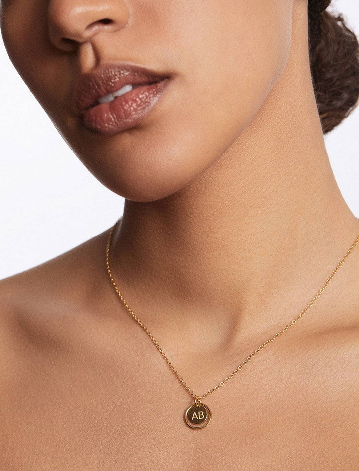 model wearing double circle engravable necklace in gold
