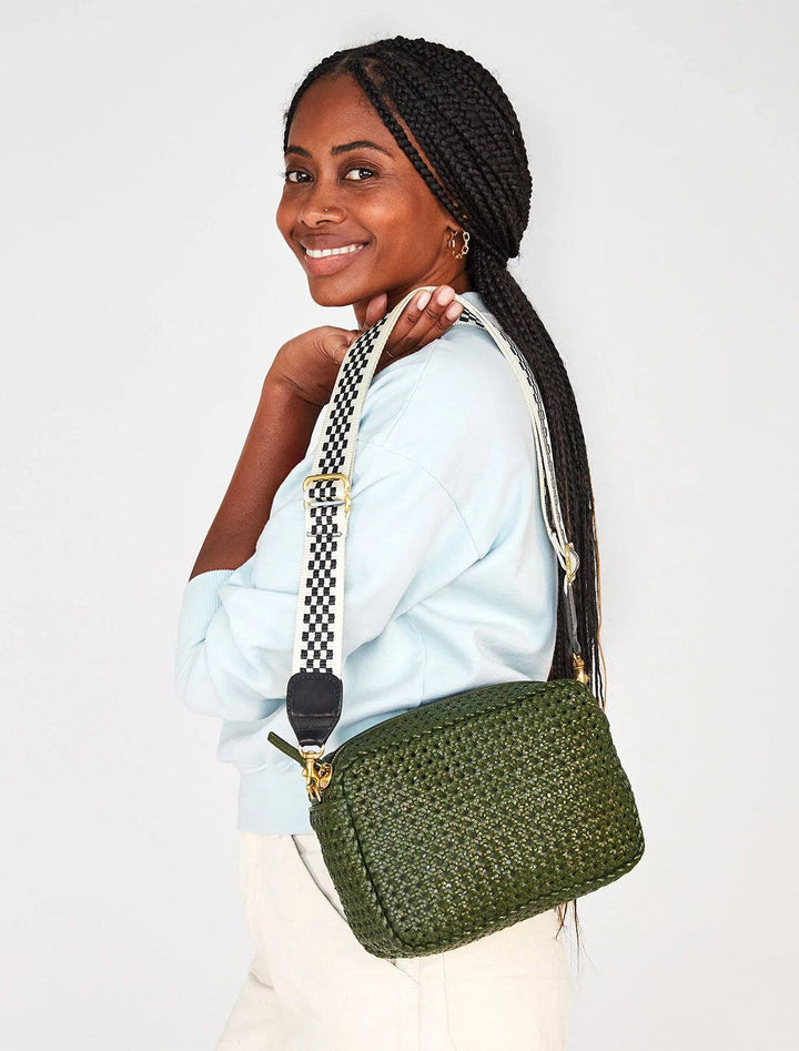 Model holding Clare V.'s marisol crossbody bag in army rattan.