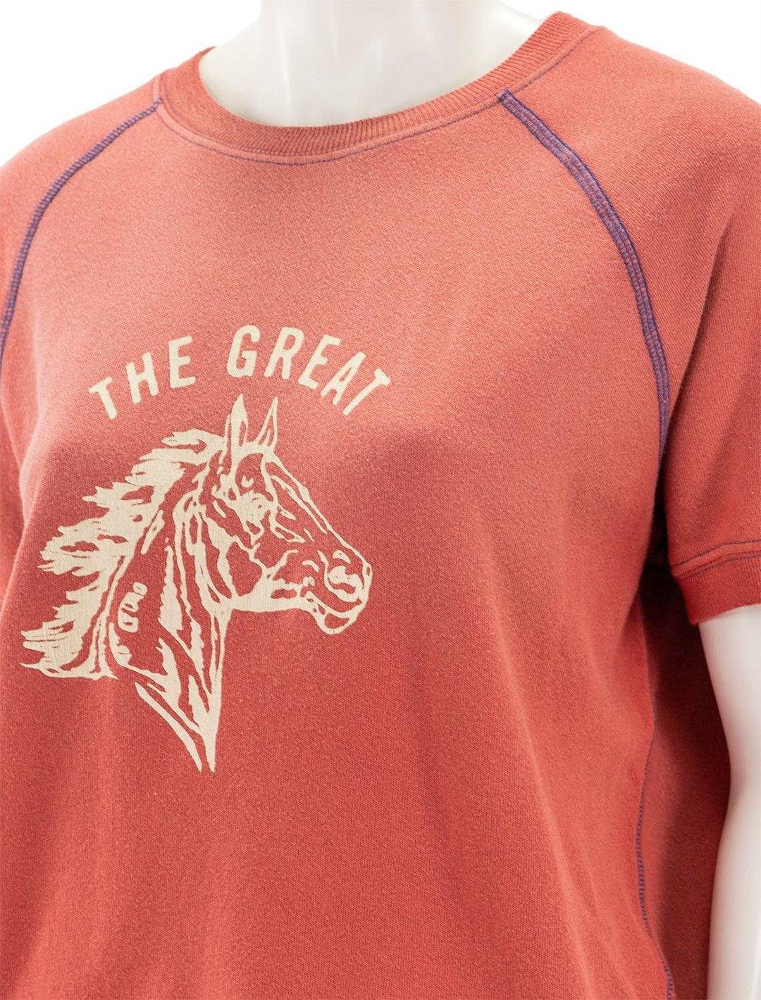 Close-up view of The Great's short sleeve bronco sweatshirt in double washed red.