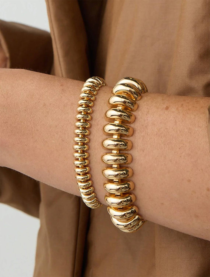 Model wearing Jenny Bird's Sofia Bracelet in Gold Tone Dipped Brass (left).
