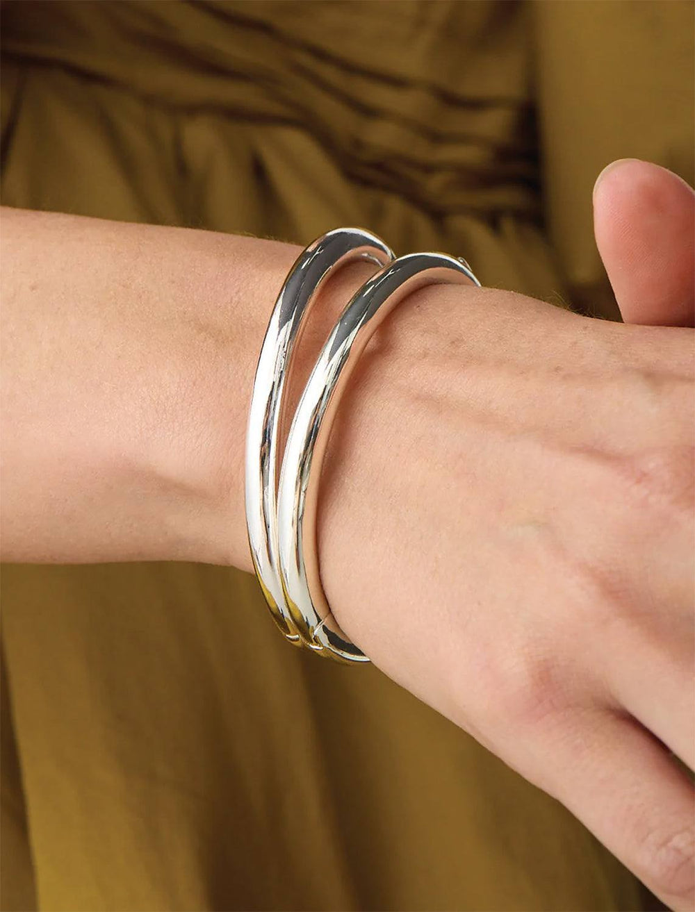 Model wearing 2 of Jenny Bird's Gia Bangle in Silver Dipped Brass.