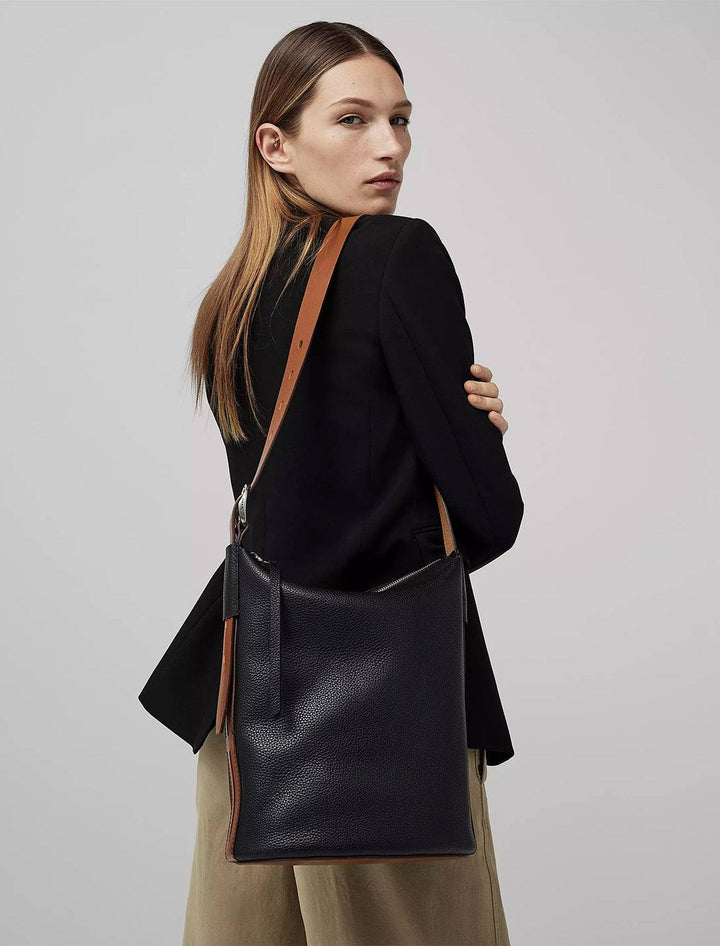Model wearing Rag & Bone's belize bag in black.