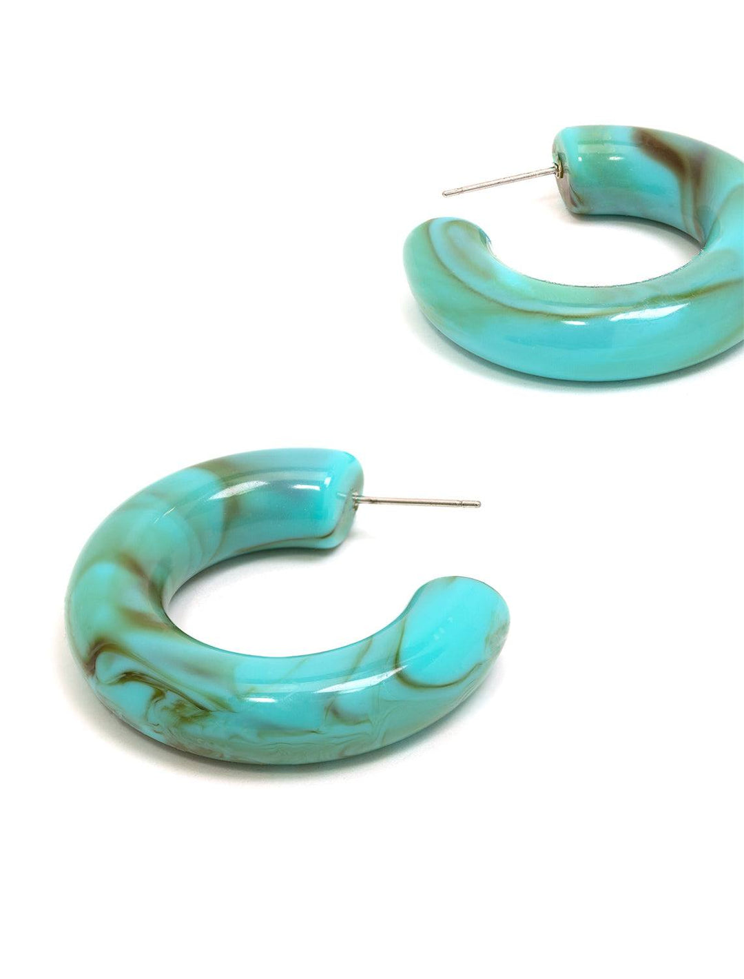 Stylized laydown of St. Armand's turquoise chunky hoops.
