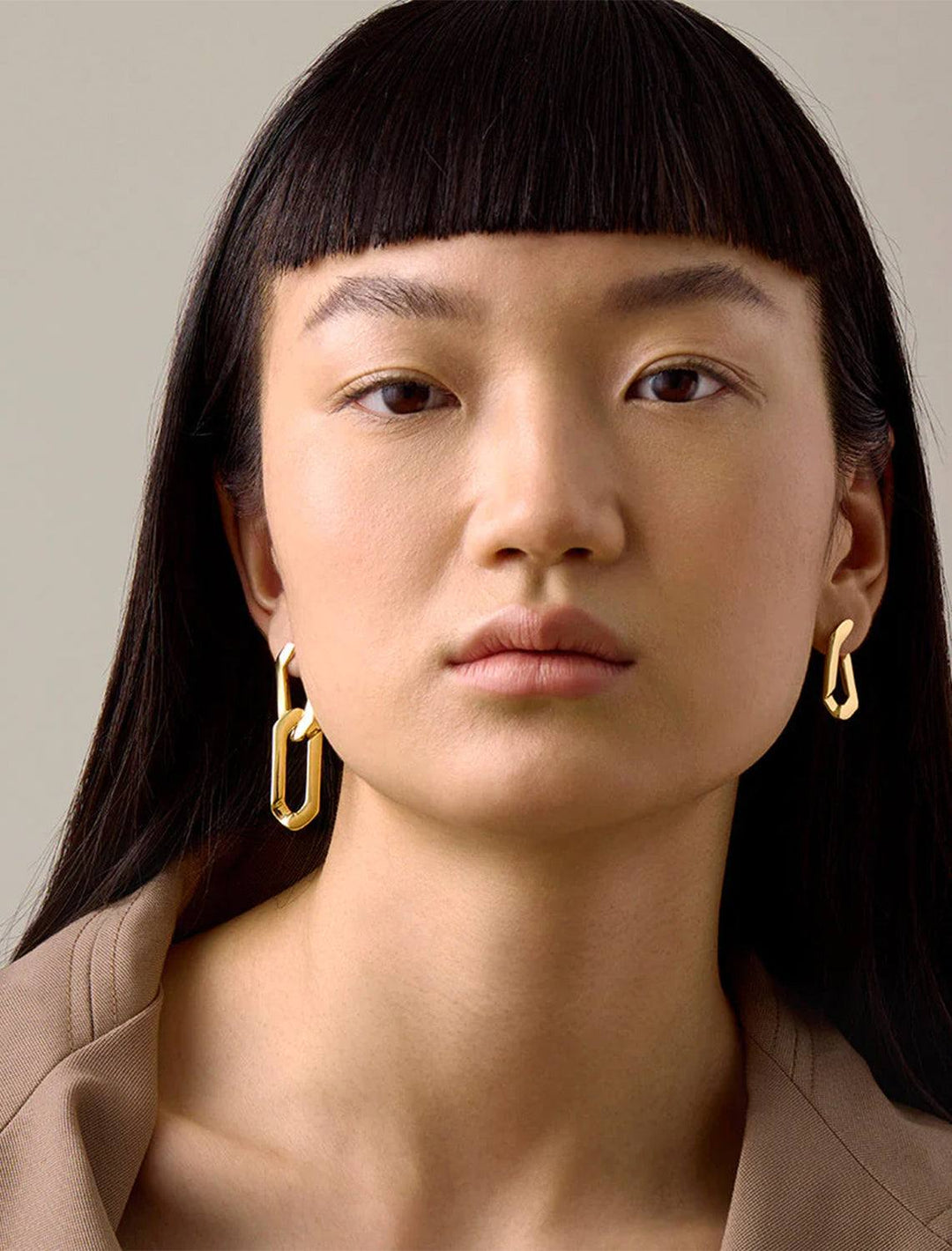Model wearing Jenny Bird's rafael earrings in gold.