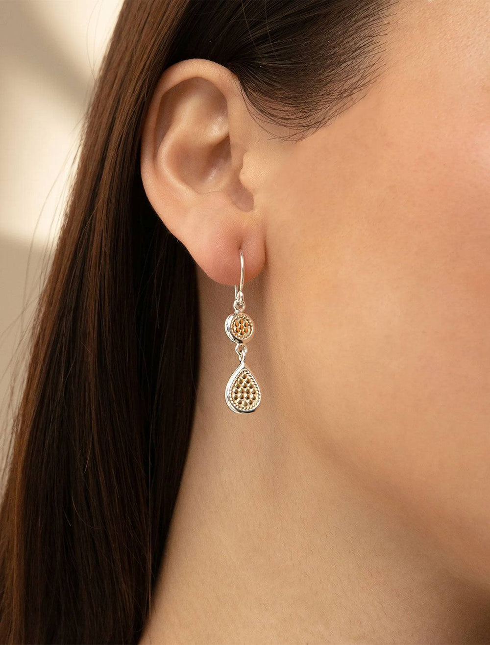 Model wearing Anna Beck's classic double drop earrings in two-tone.