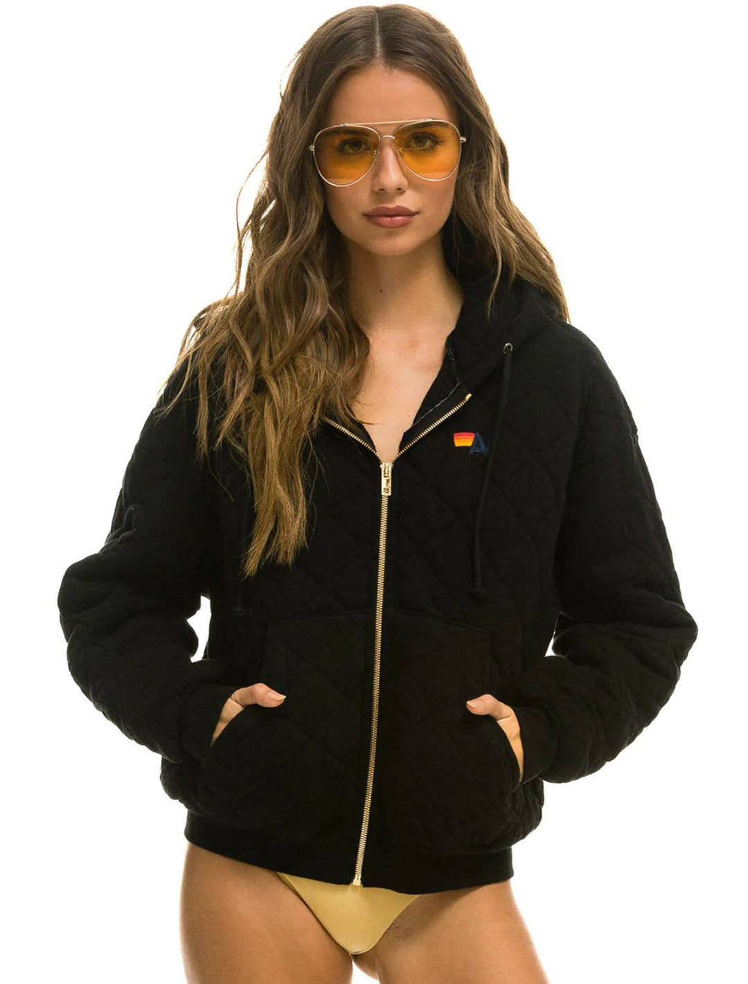 Model wearing Aviator Nation's quilted zip hoodie relaxed in black.